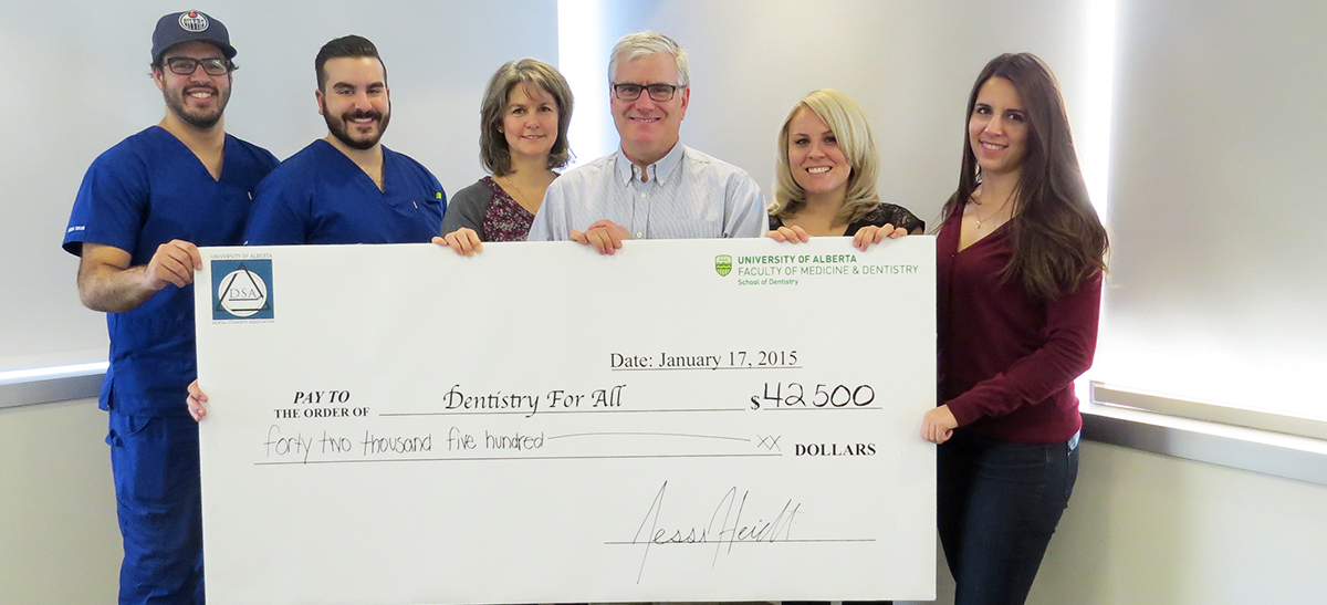 Dental students pose with a giant cheque for $42,500 for Dentistry For All