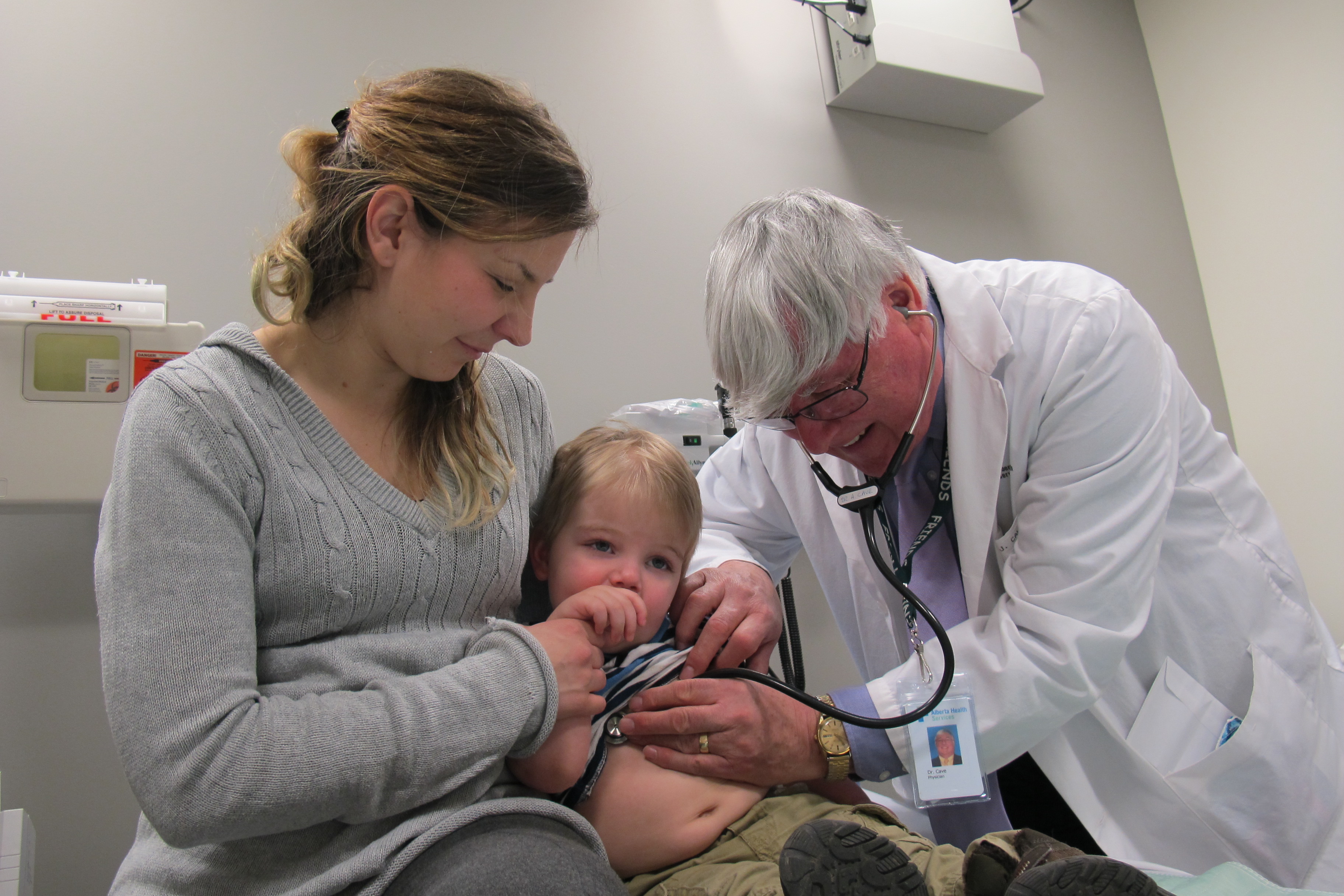Andrew Cave listens in on the breathing of two-year-old Gabriel Carlson as his mother Katherine watches on at the Kaye Edmonton Clinic.